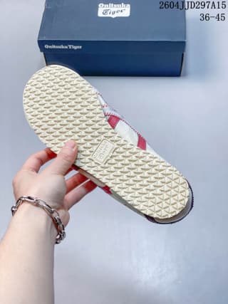 Close view of the sneaker's patterned rubber outsole and red side accents.
