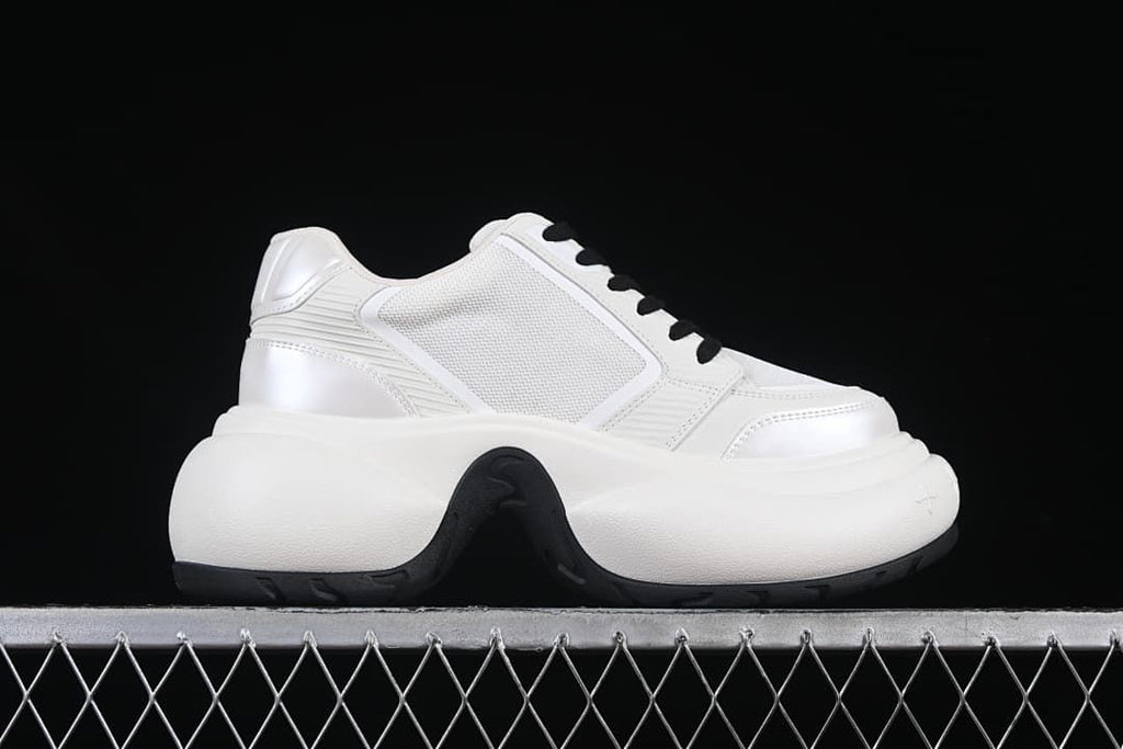 Side profile of the sneaker with a white upper and chunky sole
