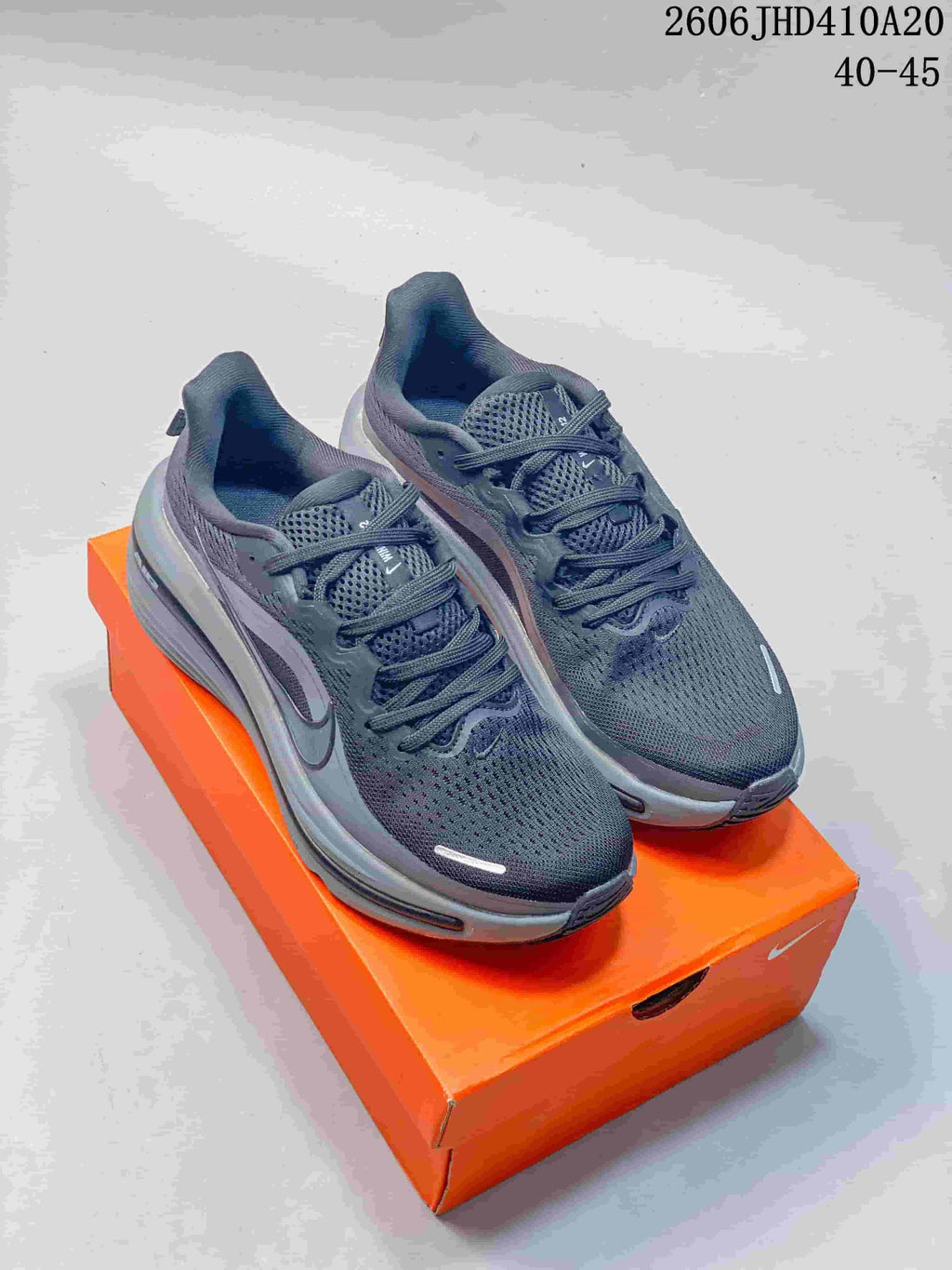 Dark gray Nike Air Zoom Winflo 12 running shoes displayed on an orange shoebox.
