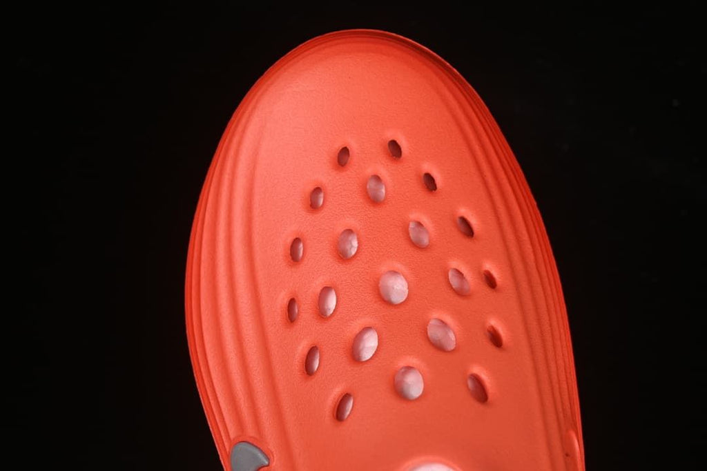 Top-down view of the perforated toe area of the orange sandal