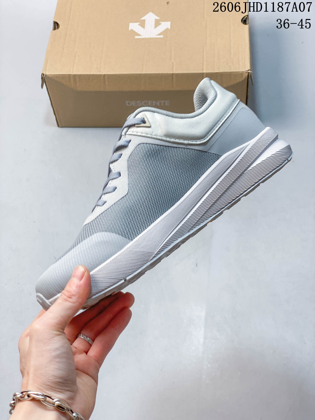 Side profile of a gray mesh-look low-top sneaker with a white sole.