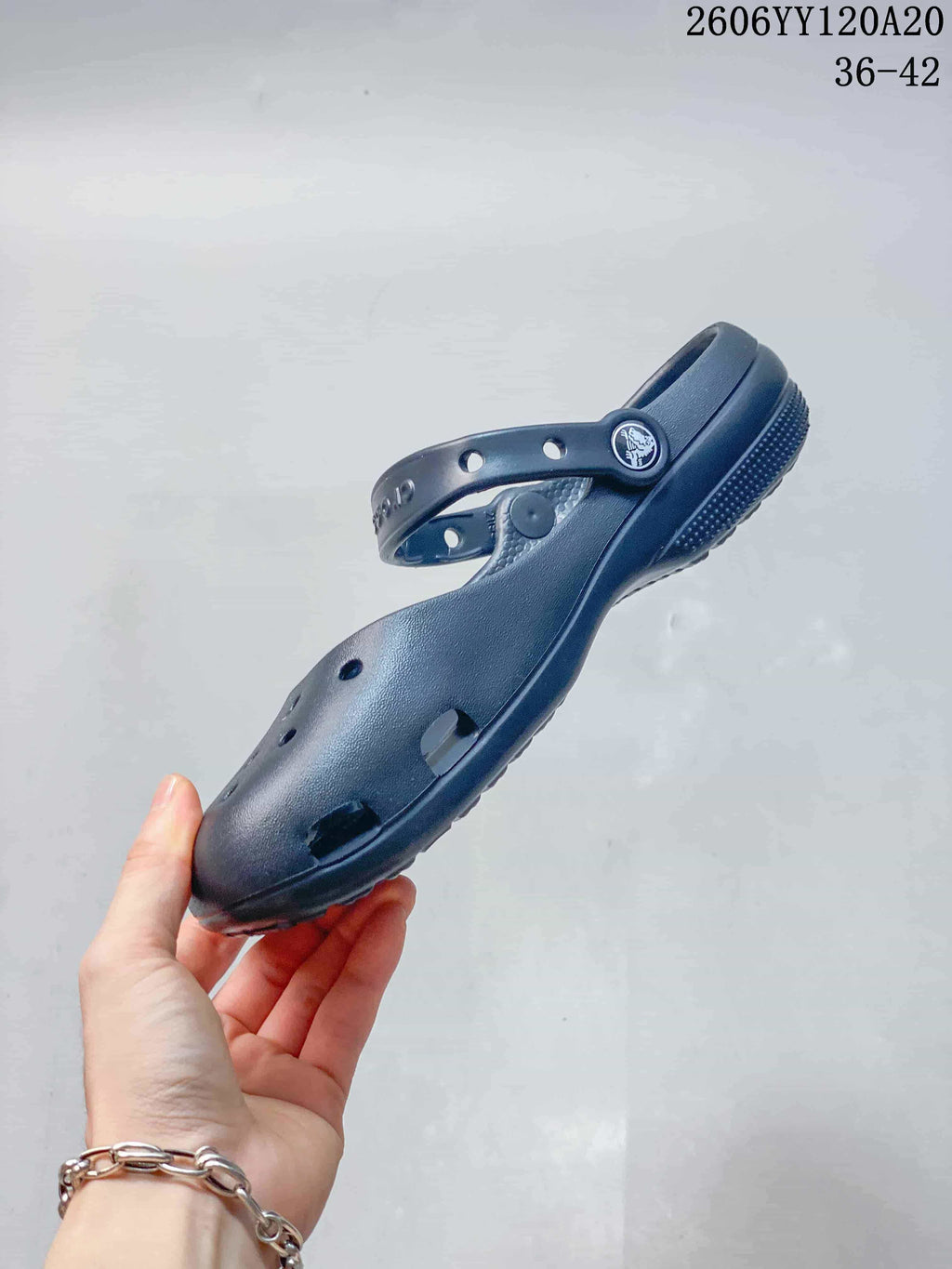 Side view of a navy clog-style shoe with ventilation openings and a pivoting heel strap; image text shows style code 2606YY120A20 and sizes 36–42.