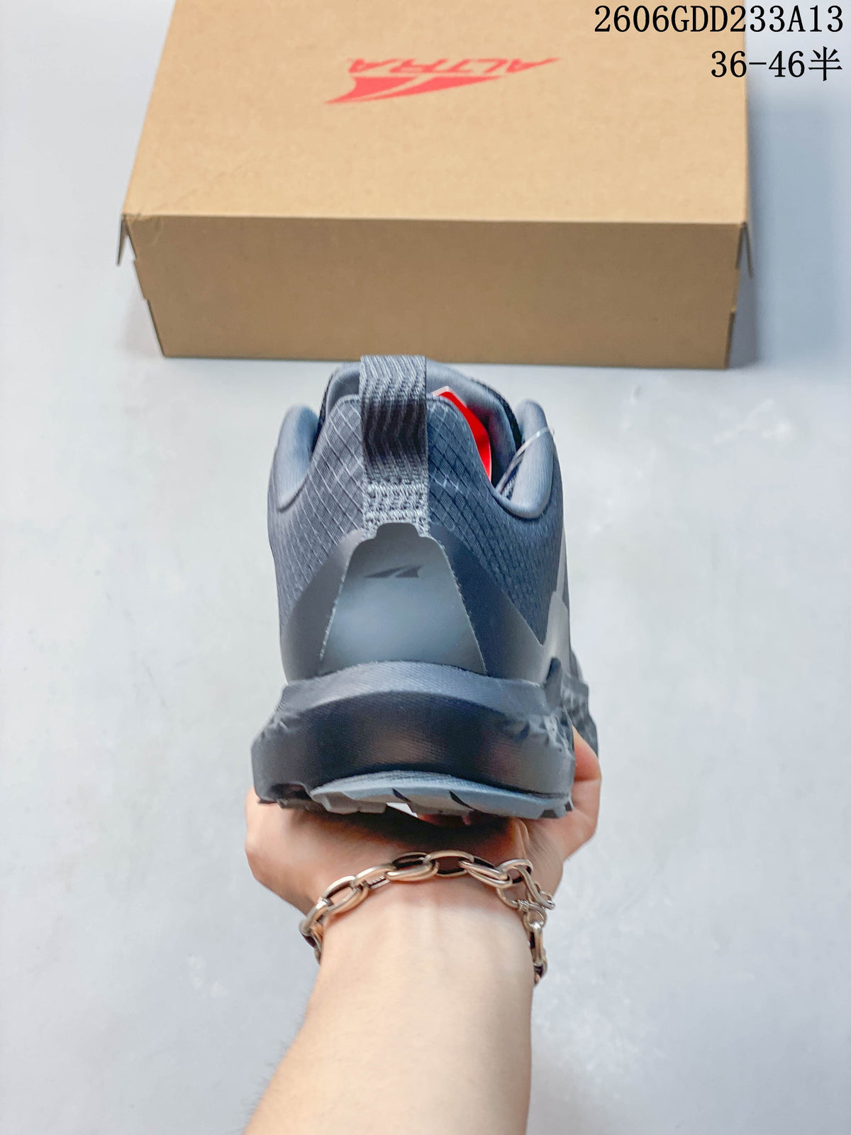 Rear view of the dark gray-blue trail shoe showing its heel and pull tab