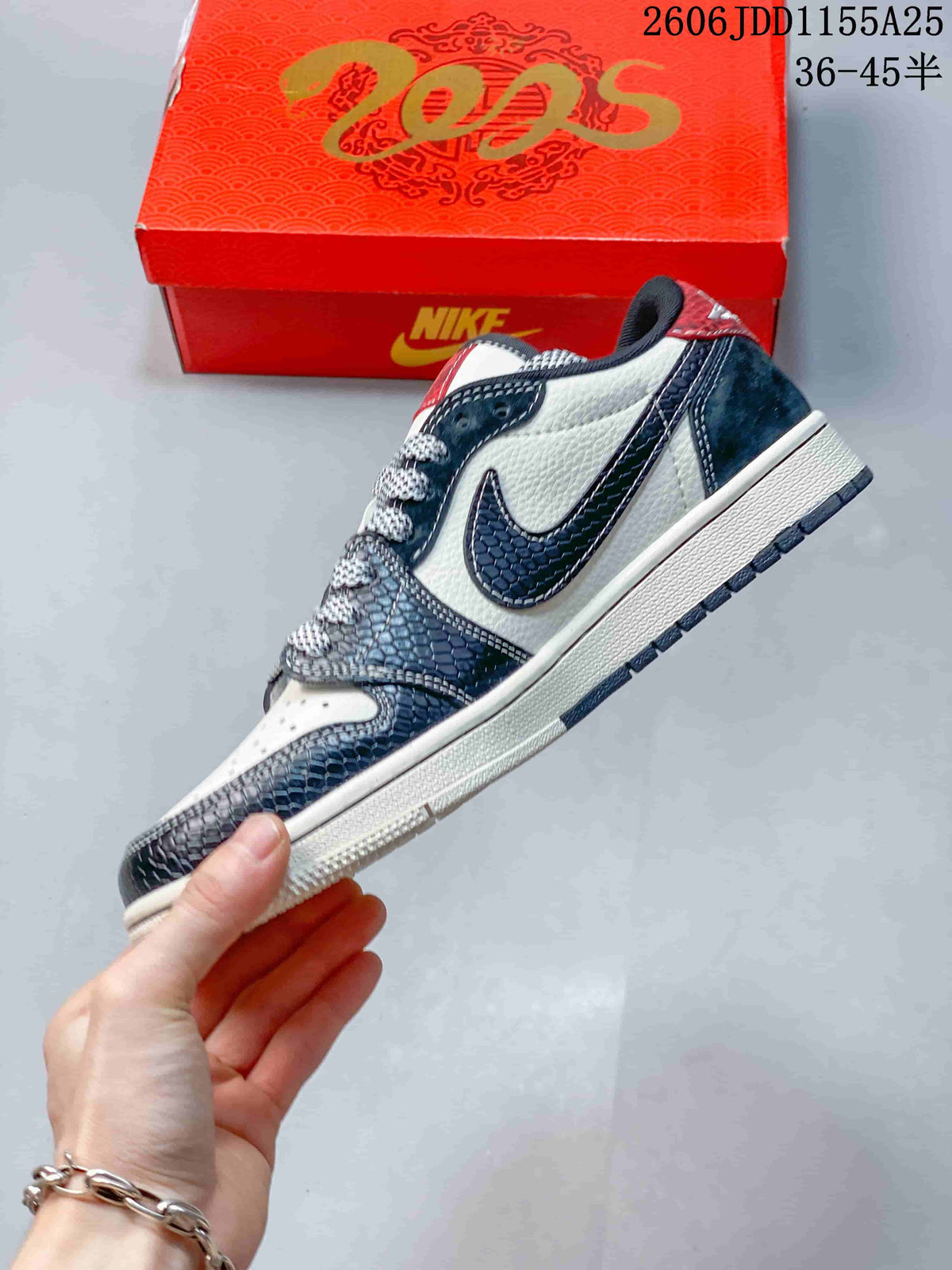 Side view of the white and navy low-top sneaker with patterned overlays