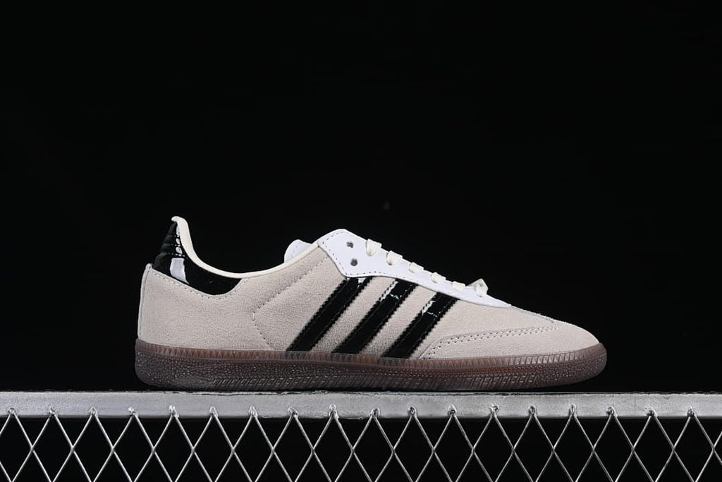 Side profile of a beige sneaker with black stripes and brown outsole
