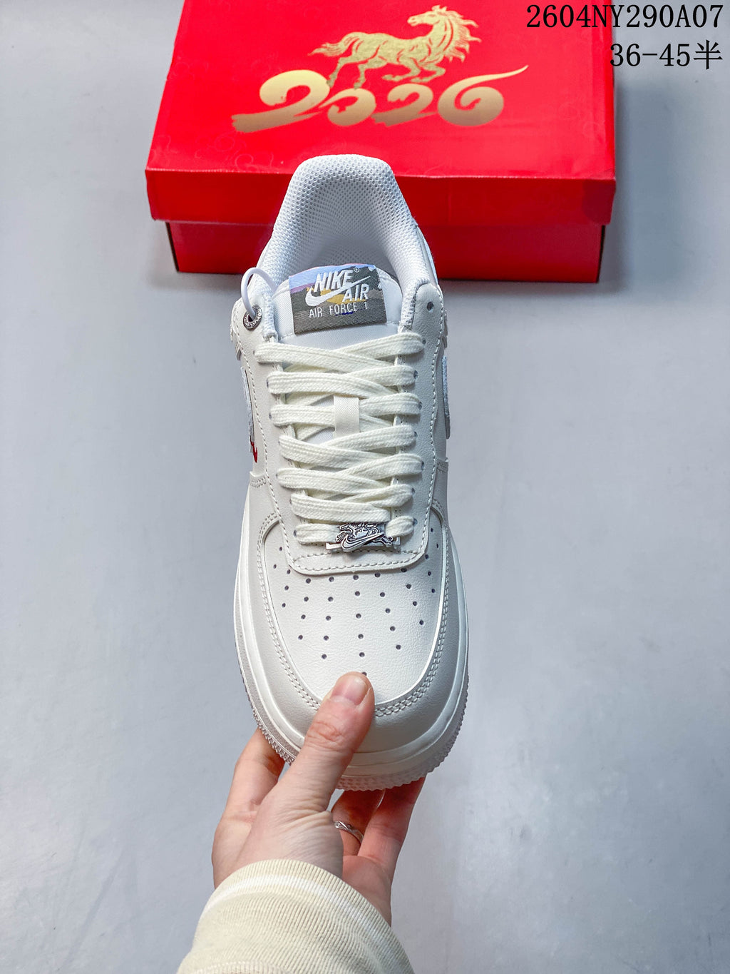 Top view of the white Air Force 1 showing perforated toe, laces, and decorative lace charm