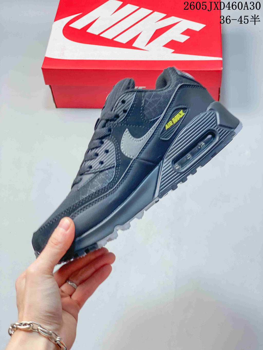 Side profile of a charcoal gray Nike Air Max 90 sneaker with visible heel Air unit