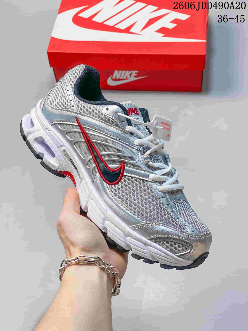 Silver and white Nike Air Max Moto 2K sneaker with a red Swoosh accent