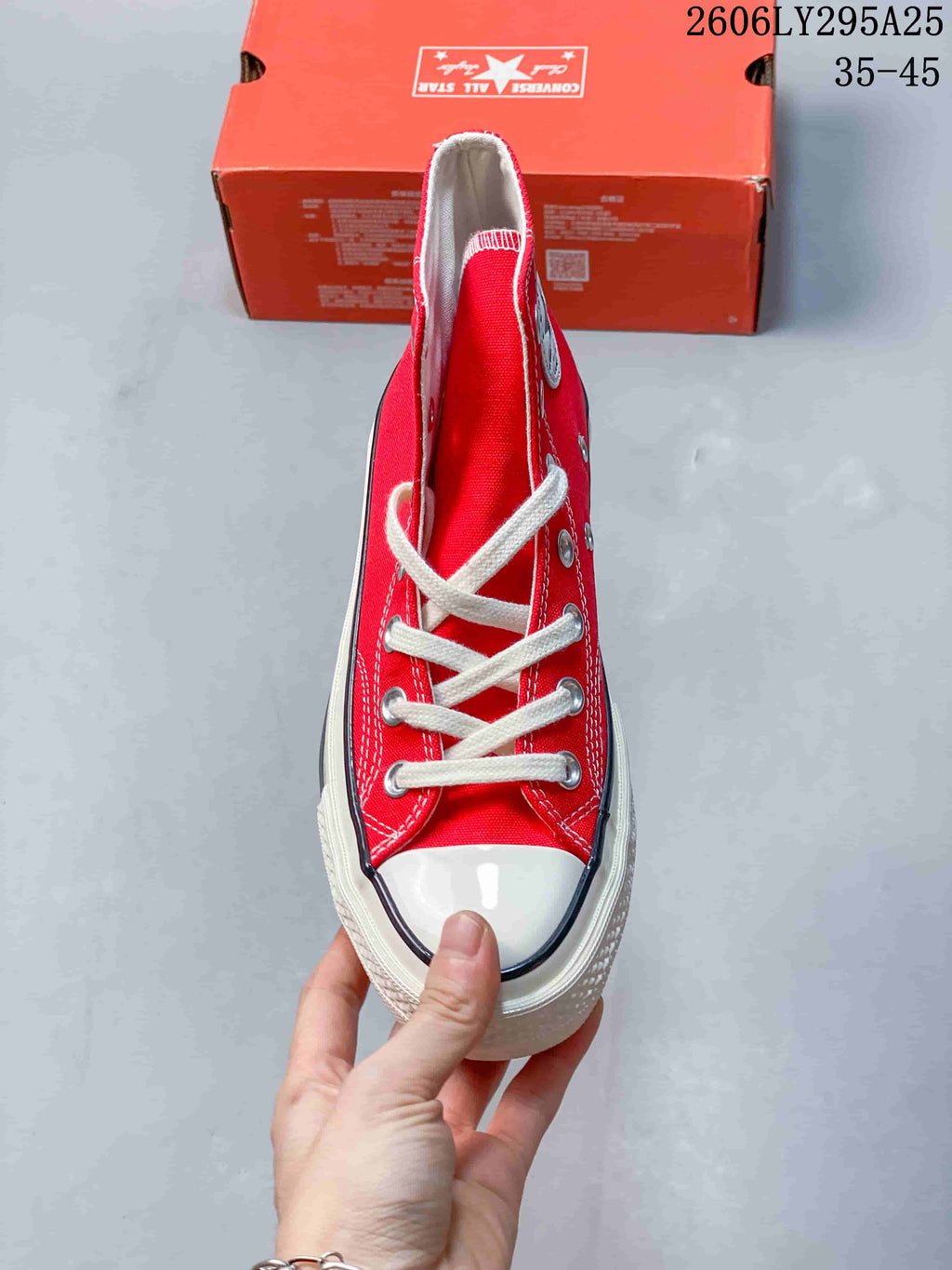 Front view of a red Converse high-top sneaker with white laces and toe cap