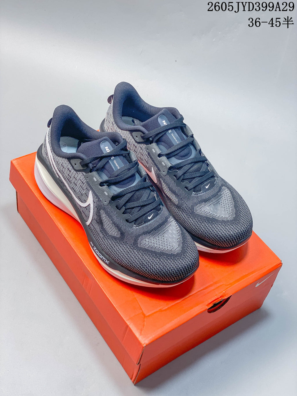 Pair of grey Nike Air Zoom Vomero 17 running shoes on an orange shoe box