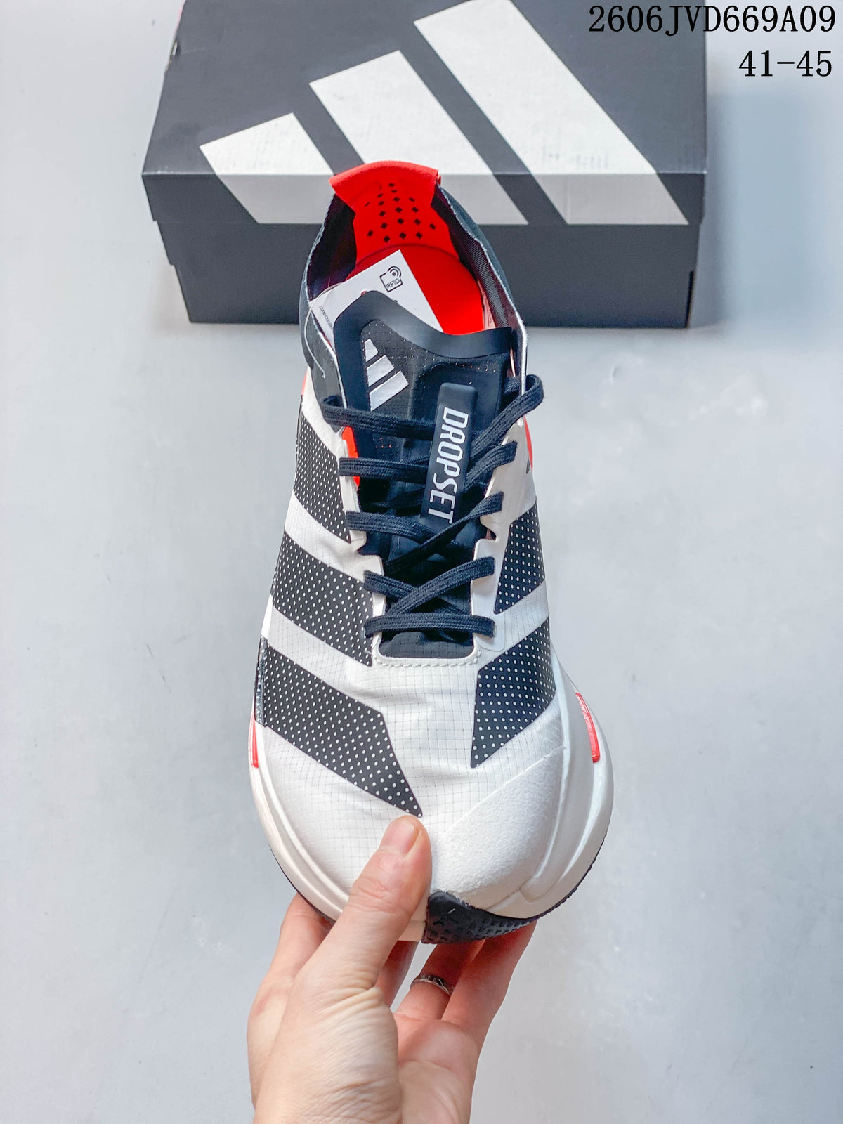 Front view showing the white upper, dark lace area, and three-stripe detailing