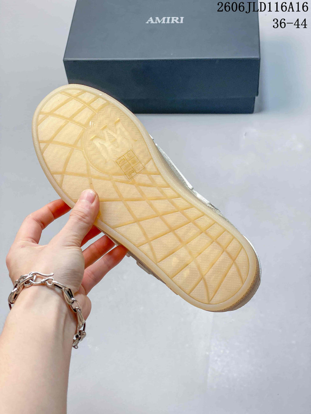 Close-up of the sneaker's translucent gum-colored outsole, with the AMIRI shoe box behind it.