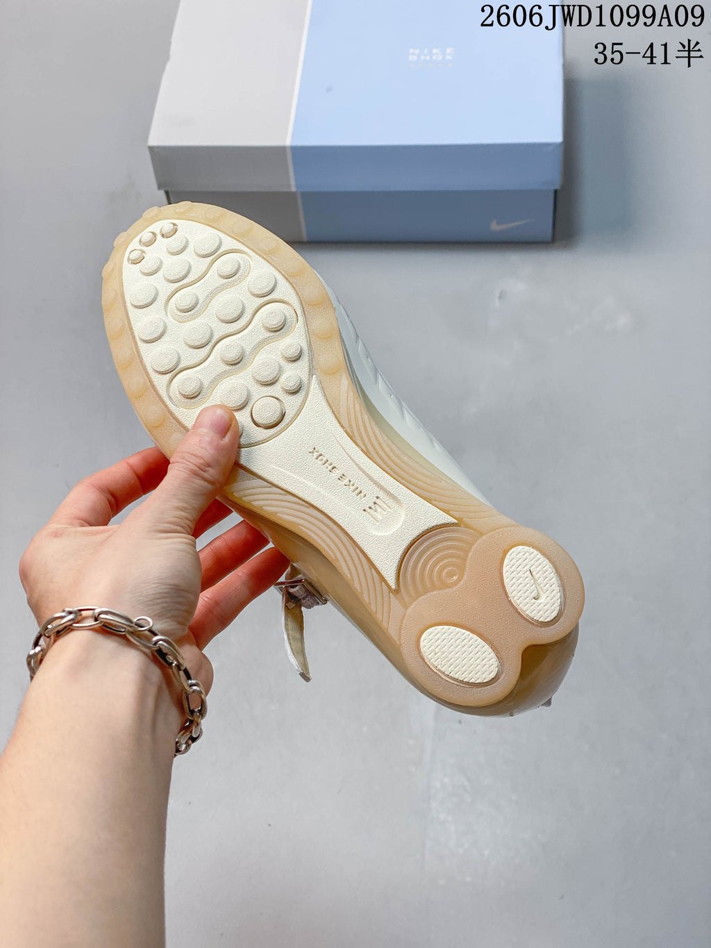 Outsole view showing the circular tread and sculpted heel of an ivory sneaker