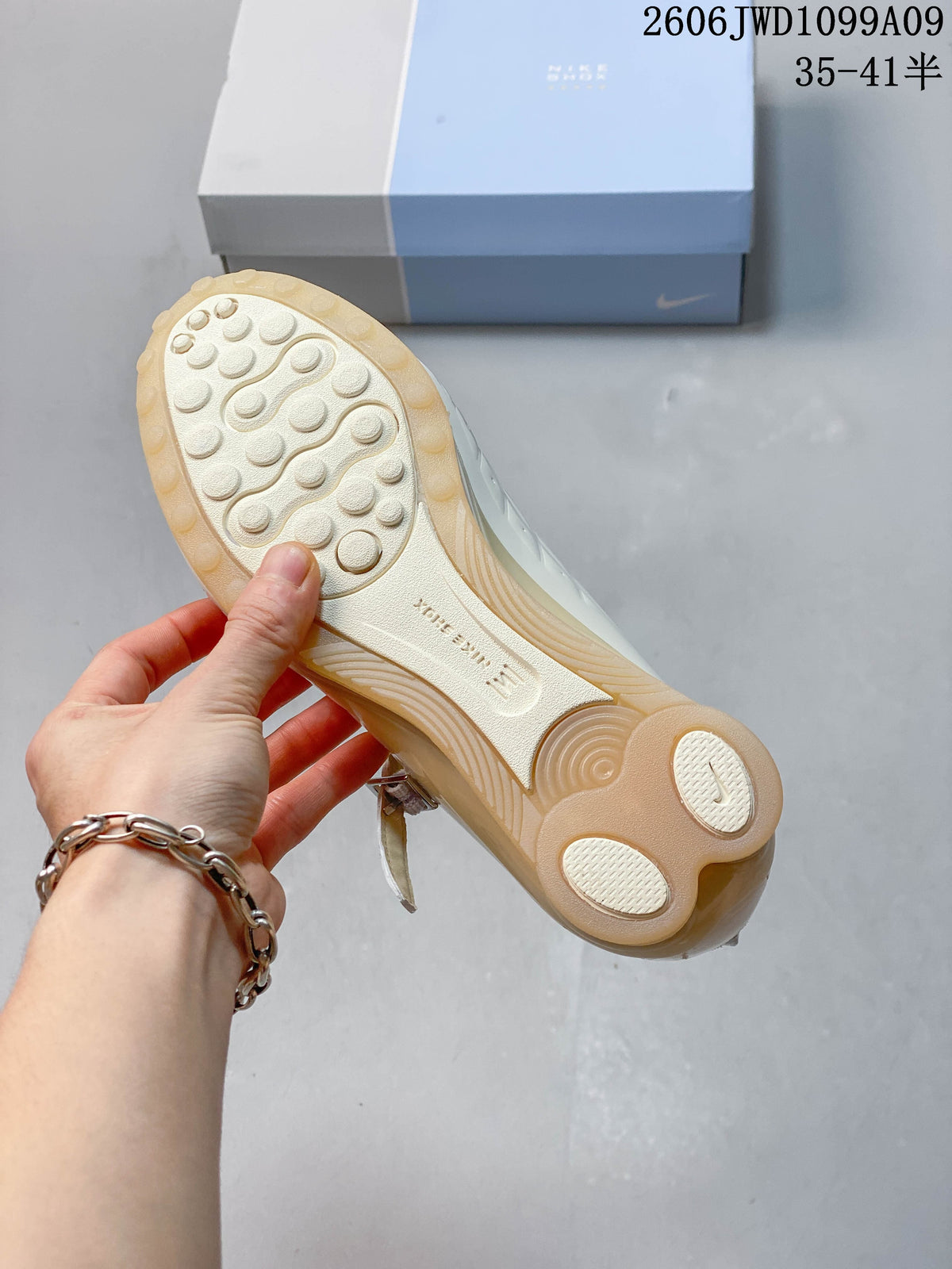 Outsole view showing the circular tread and sculpted heel of an ivory sneaker