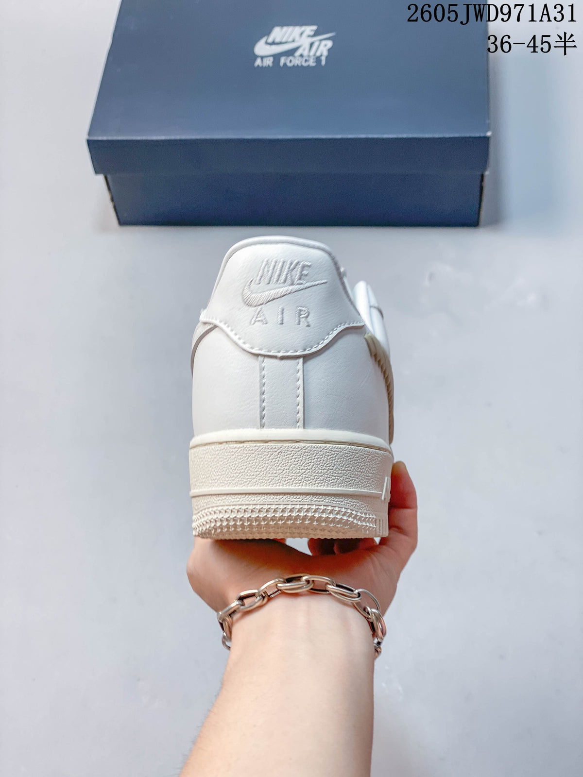 Rear view of a white low-top sneaker with a padded heel and textured beige-toned sole.