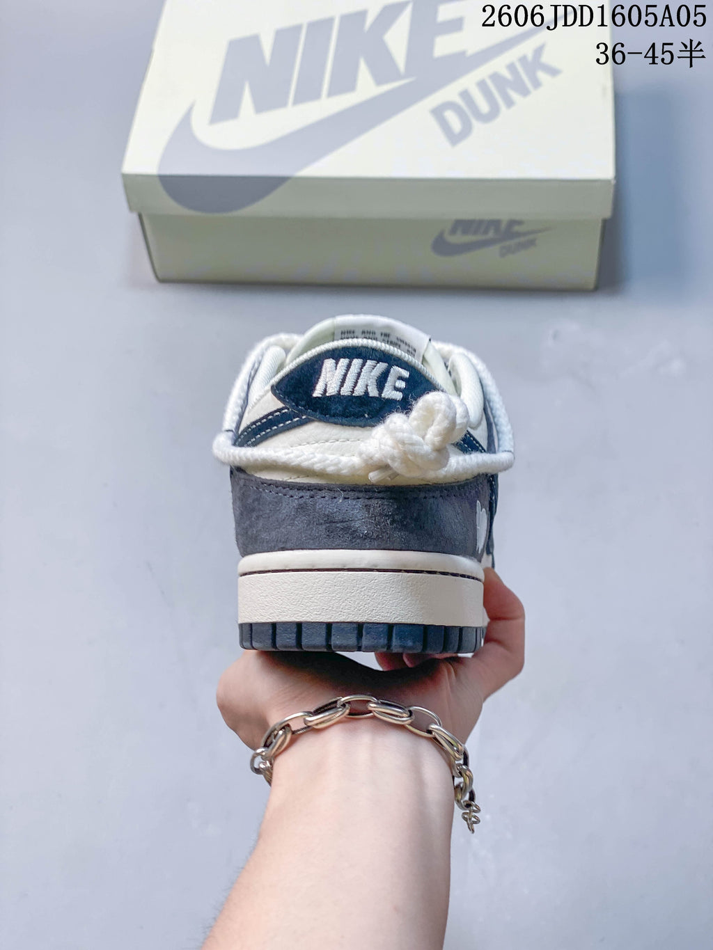 Rear view of a Nike SB Dunk Low sneaker with white laces and navy heel details