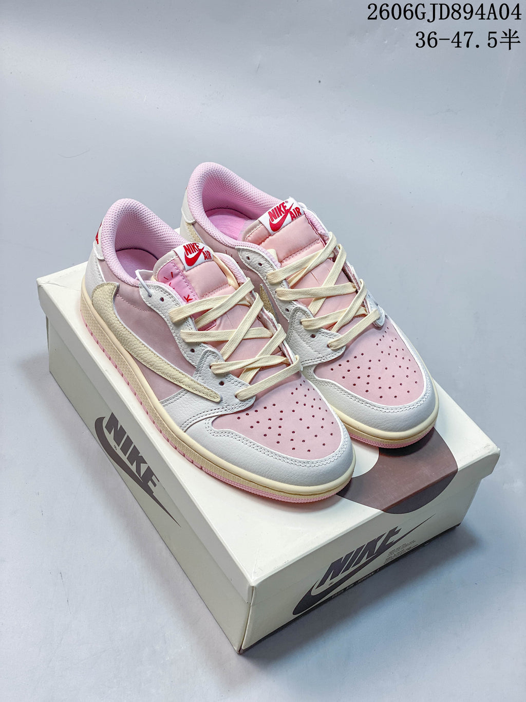Pair of pink, white, and cream low-top sneakers displayed on a shoe box