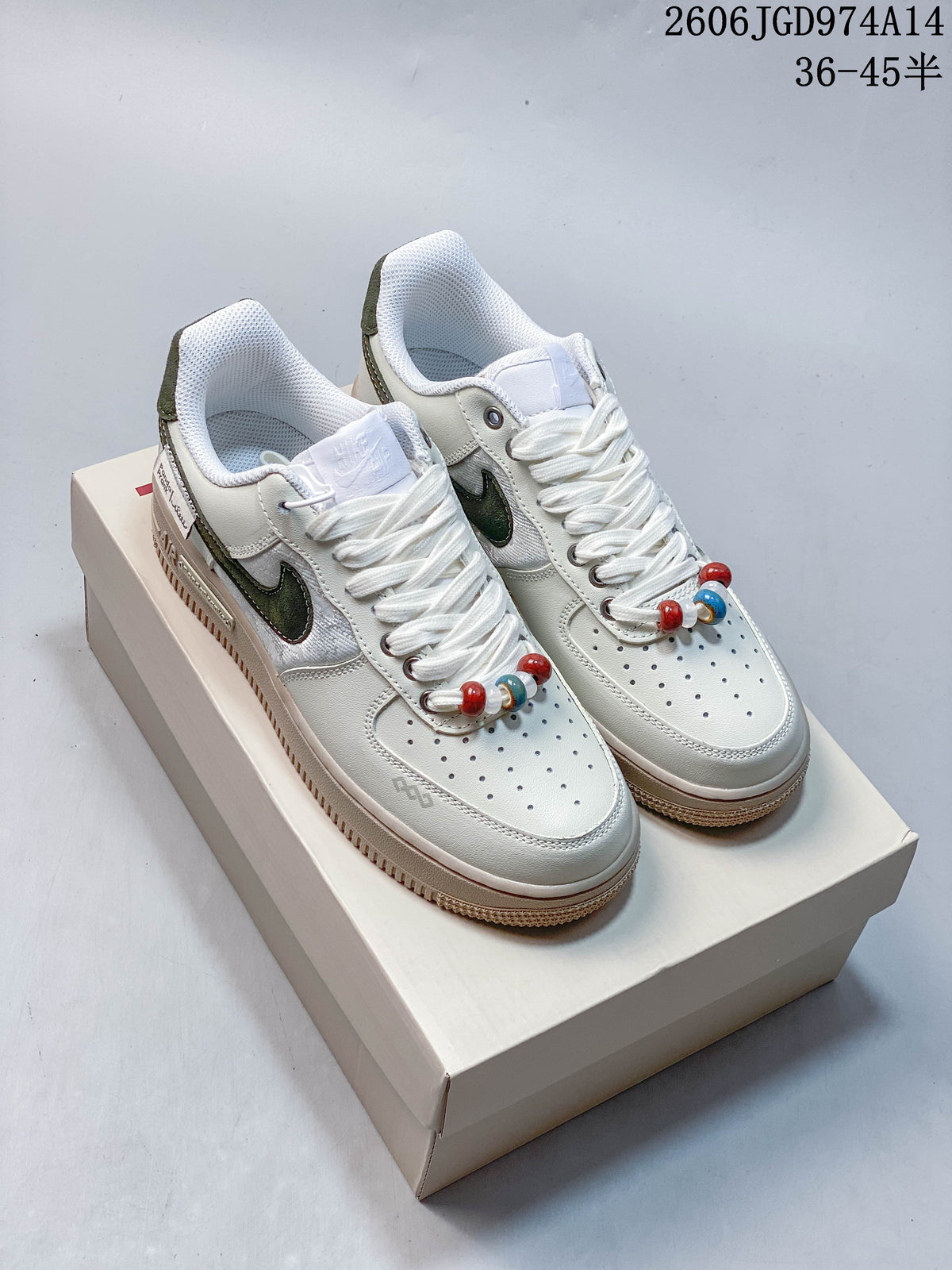Pair of white low-top sneakers with dark green accents, multicolor lace beads, and raised beige-toned soles