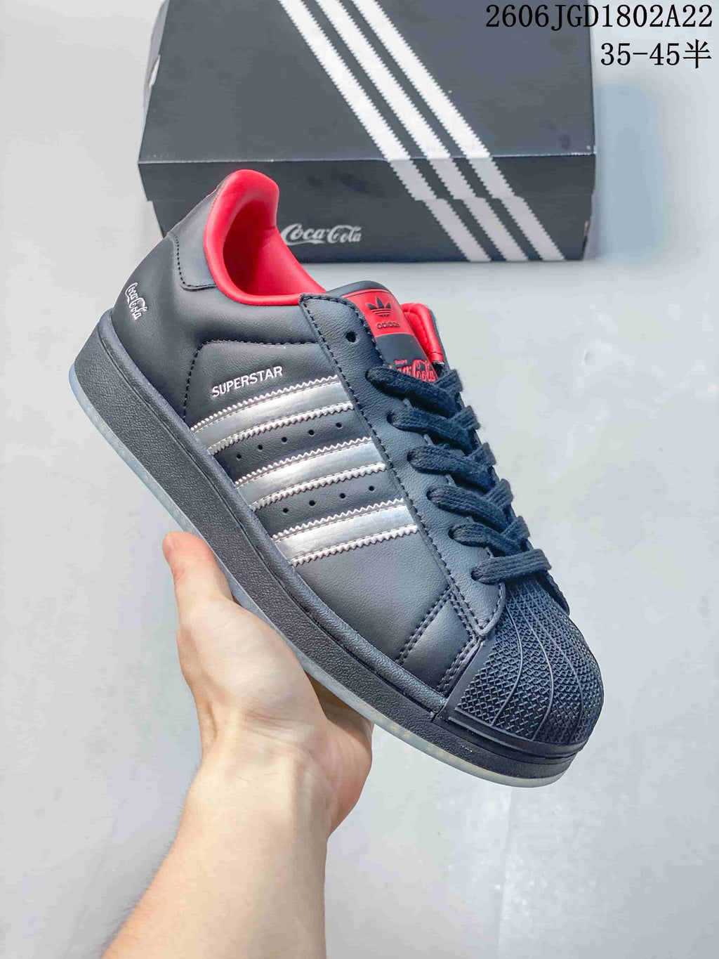 Close-up of a dark navy sneaker with silver stripes, red lining, and Superstar text.