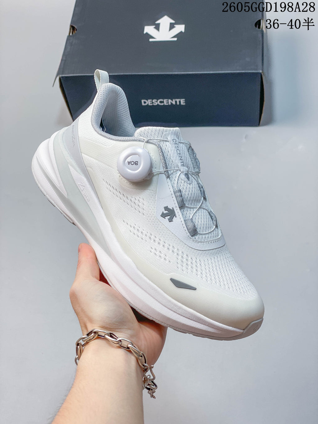 Side view of a white DESCENTE running shoe with a BOA dial and thick sole.