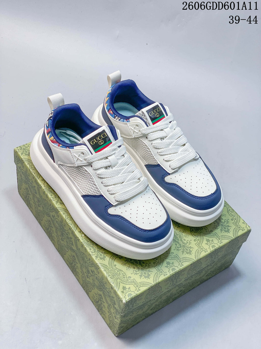Pair of white and blue Gucci Screener GG sneakers with embroidered collar details, shown from the front.