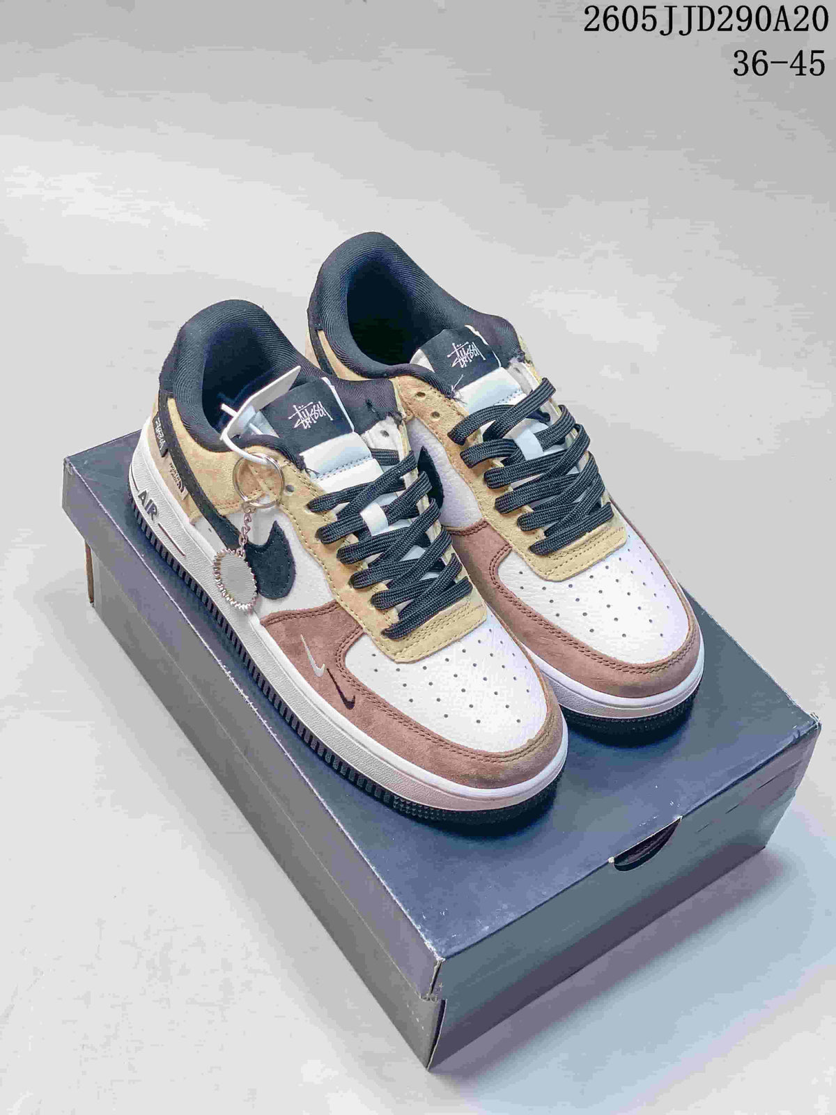 Pair of multicolor Nike low-top sneakers with layered white, tan, dusty rose, and black panels