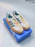 Pair of light-colored Adidas Gazelle Bold W sneakers with green stripes and gum-colored platform soles.