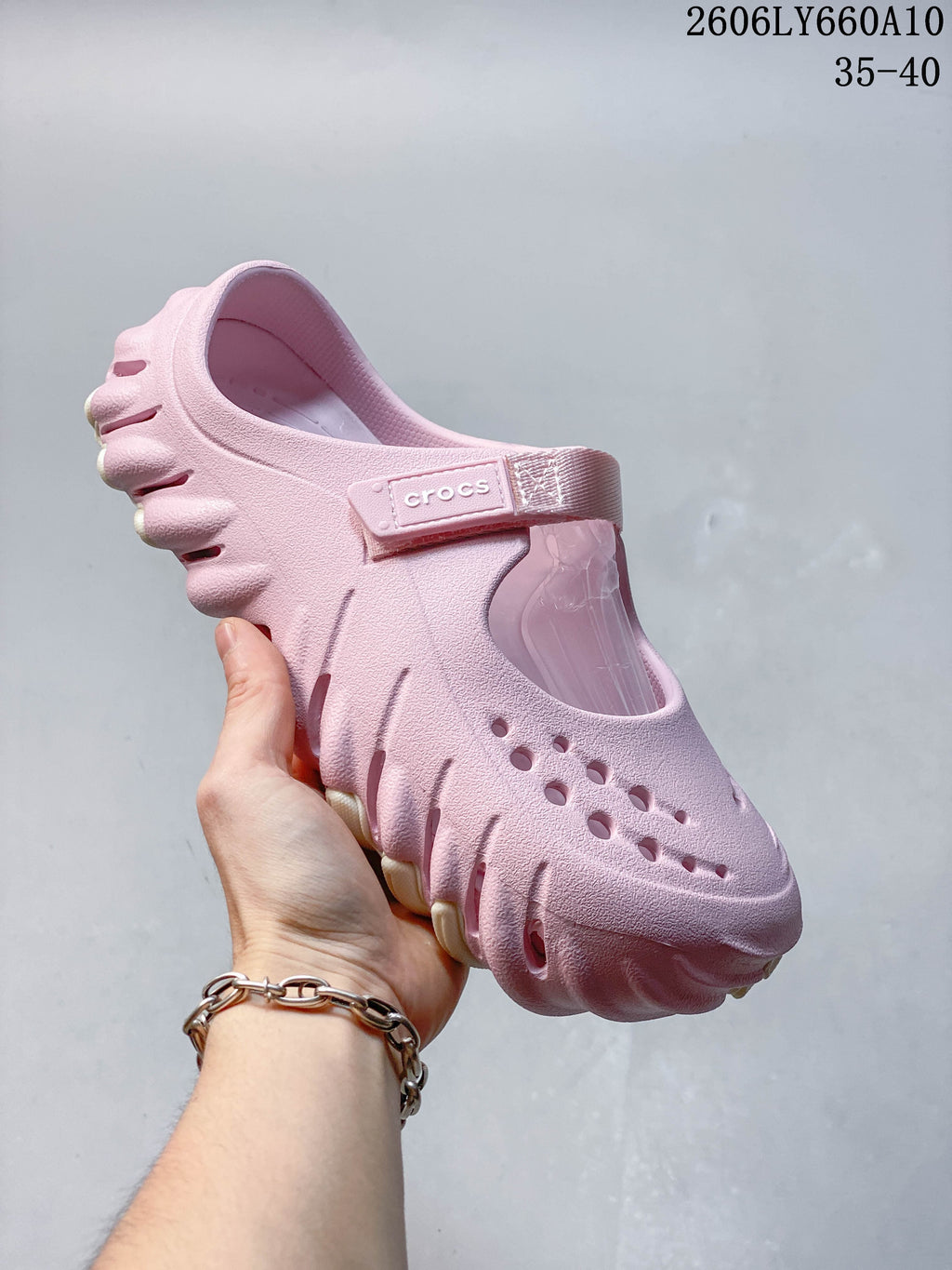 Side view of a pink Crocs Mary Jane-style clog showing the perforated upper, instep strap and sculpted sole.