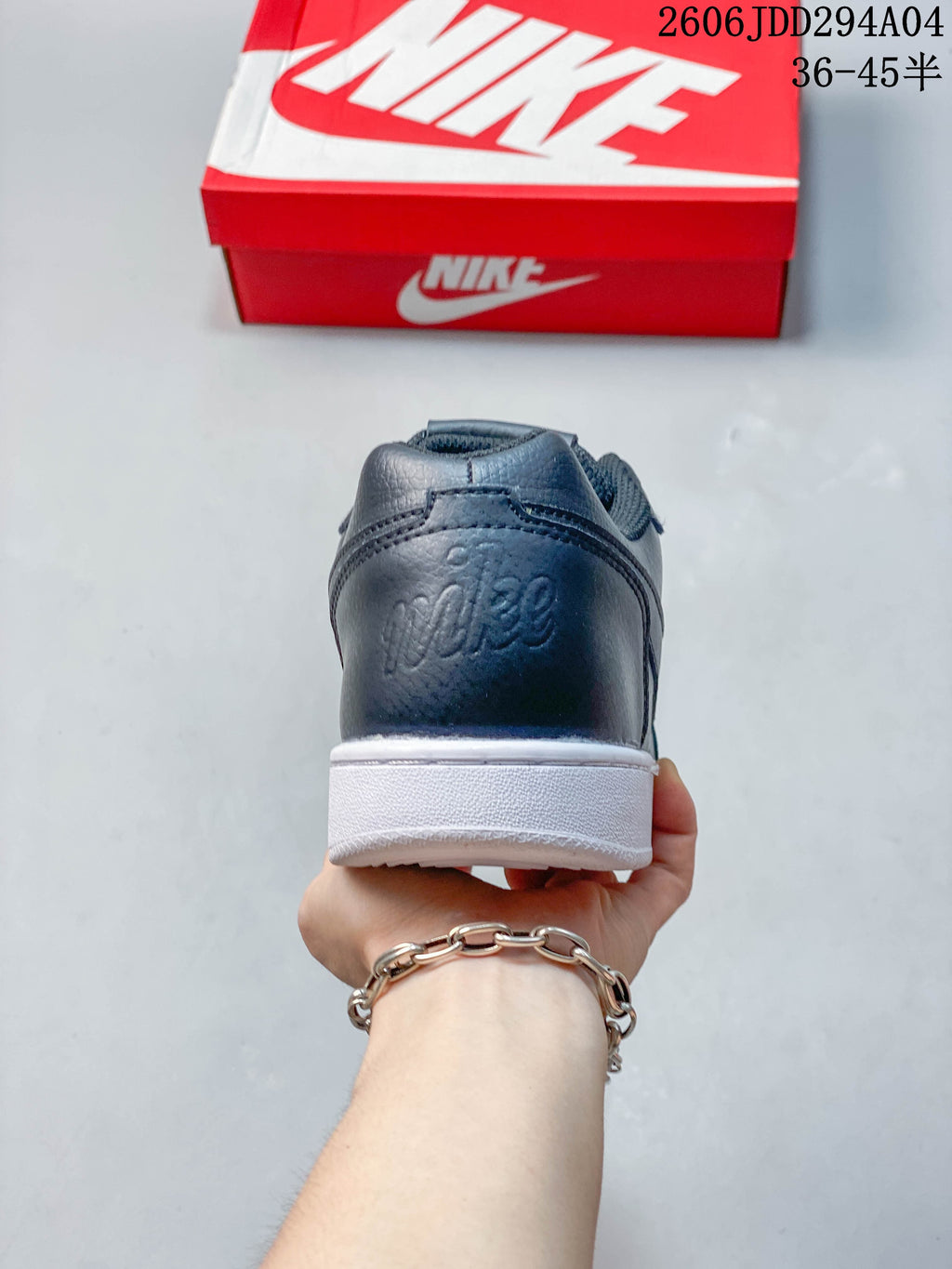Rear view of the dark gray sneaker showing heel branding and white sole