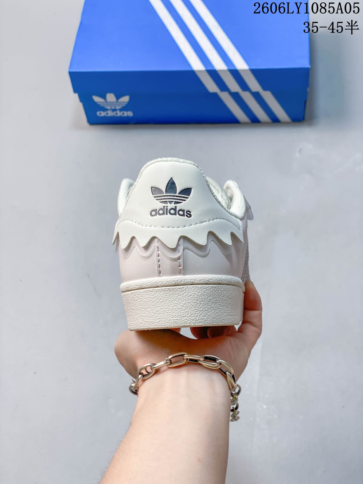 Rear view of the sneaker with a trefoil logo and pale pink heel panel