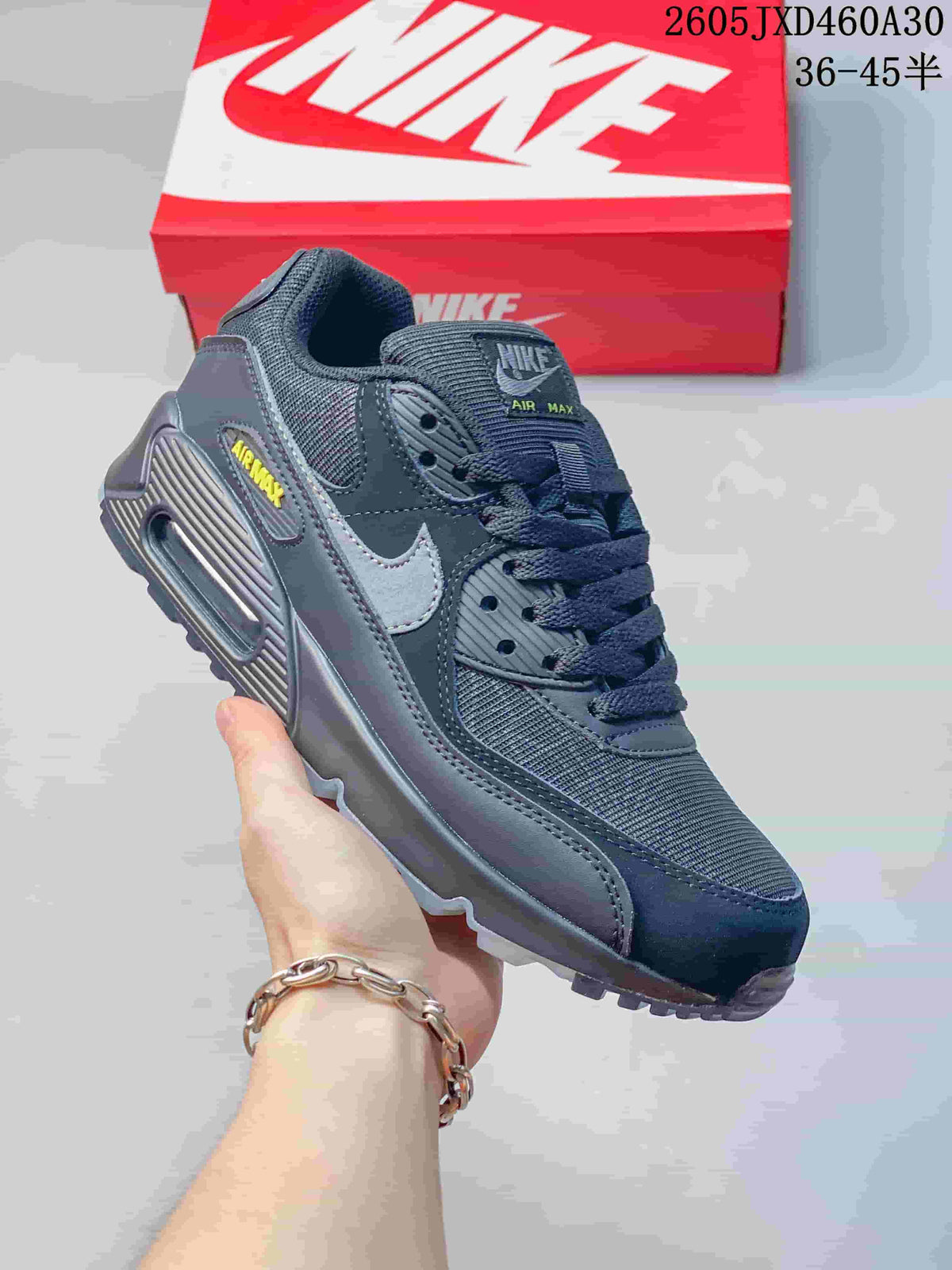 Angled side view of a charcoal gray Nike Air Max 90 sneaker