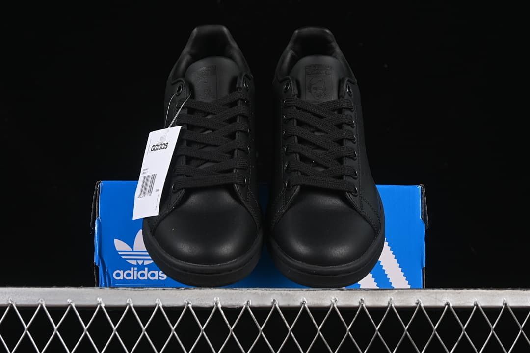 Front view of the pair of black sneakers displayed on the shoebox