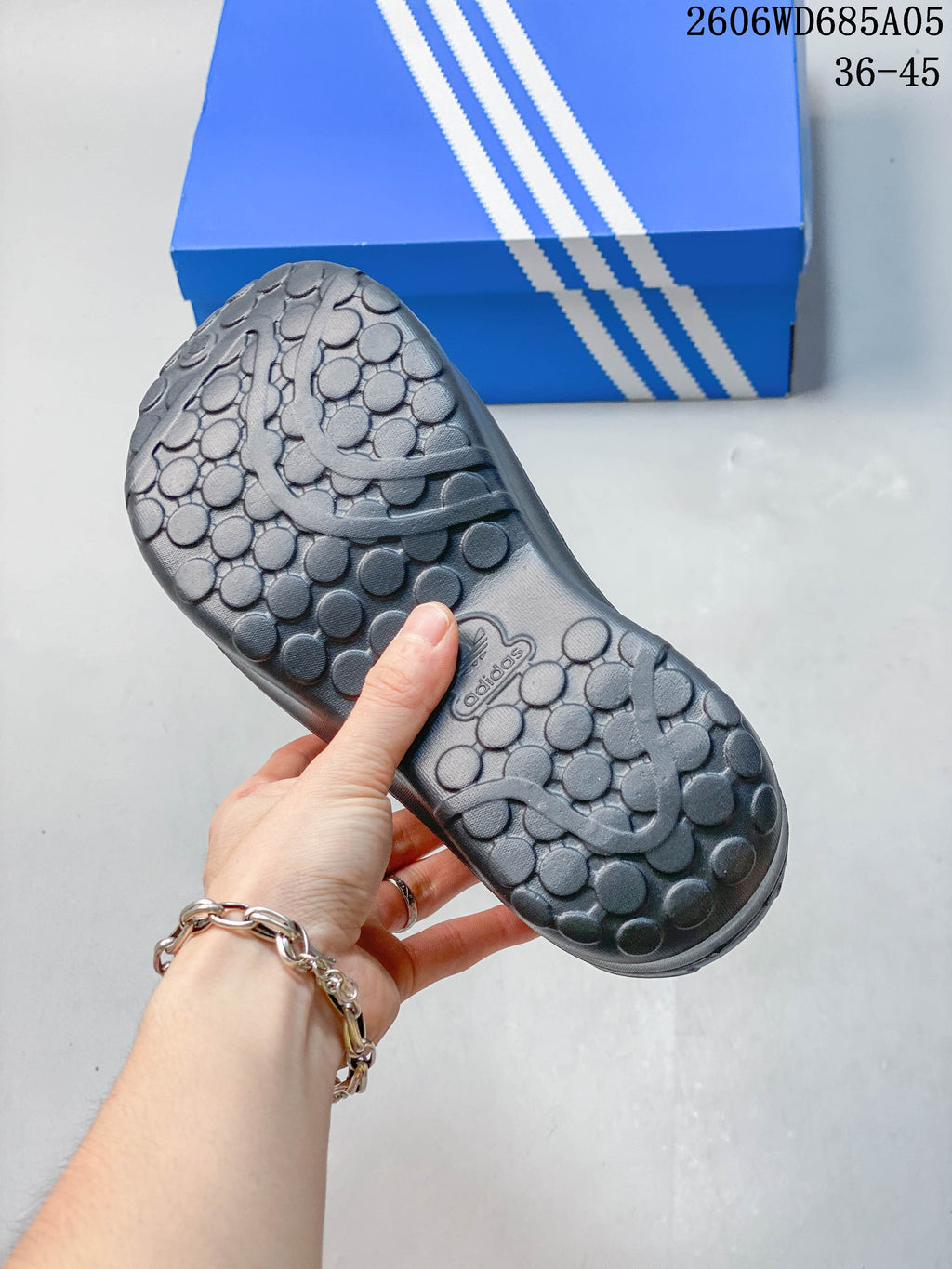 Textured outsole of the Adidas mule with a circular tread pattern
