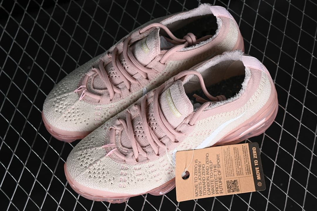 Pair of light pink and cream shoes shown with a hangtag.