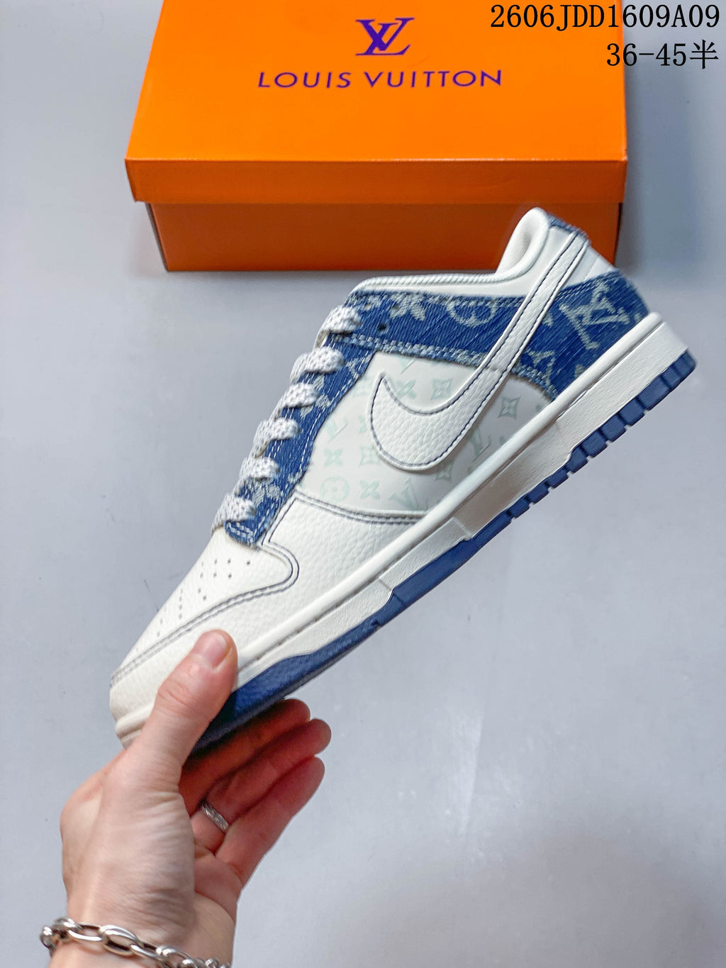 Side profile of a cream sneaker with blue denim-print panels and patterned side section