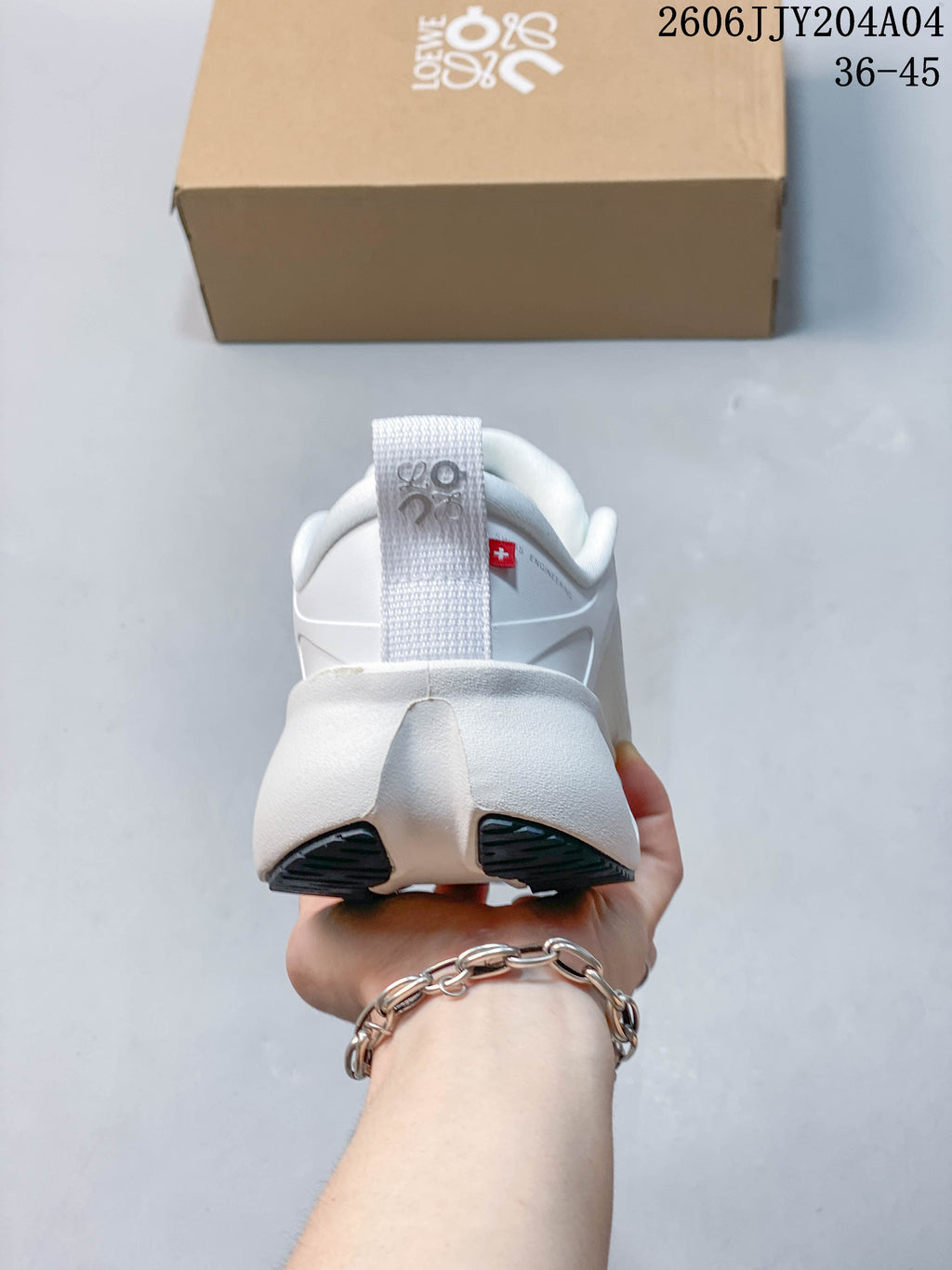 Rear view of a white sneaker with heel pull tab
