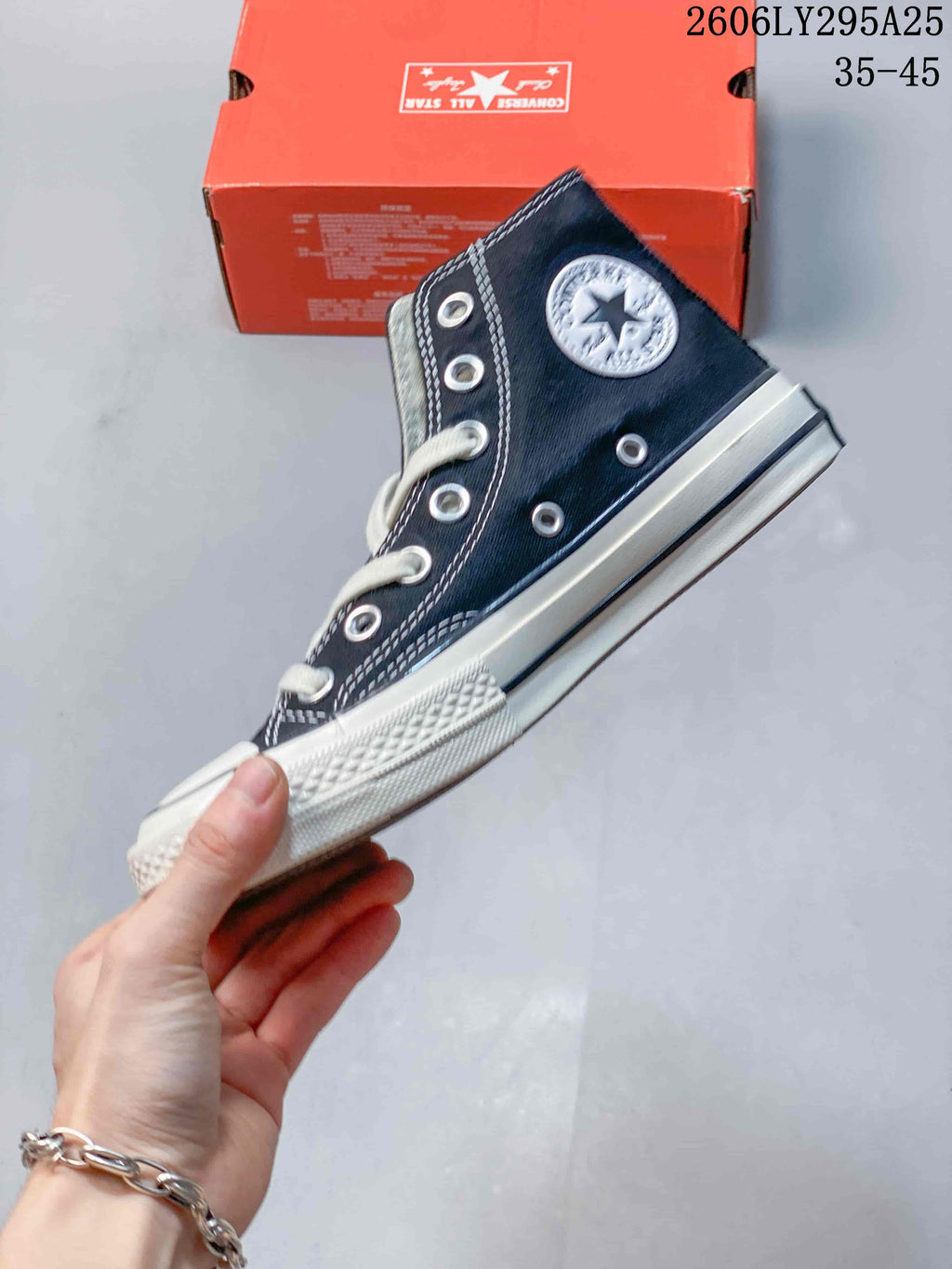 Side view of the navy high-top sneaker with metal eyelets and a rubber toe cap