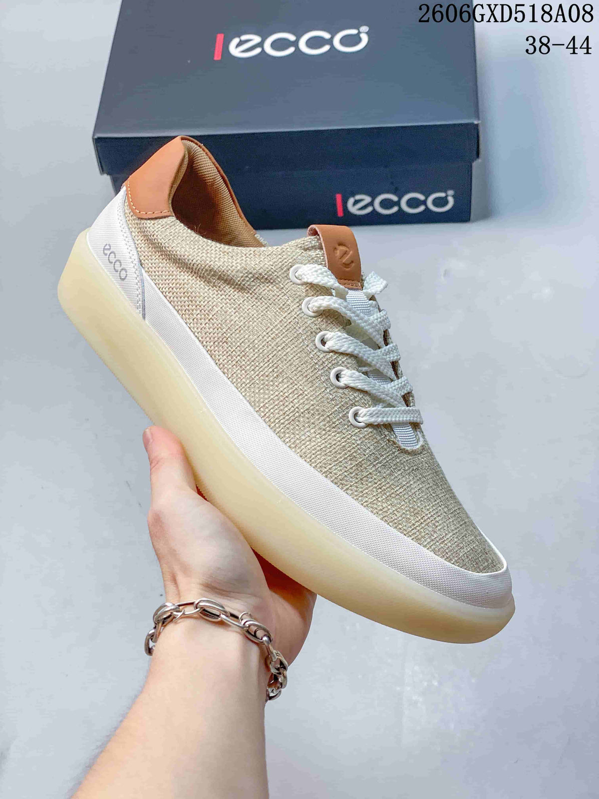 Angled side view of a beige lace-up sneaker with white trim and tan heel accent.