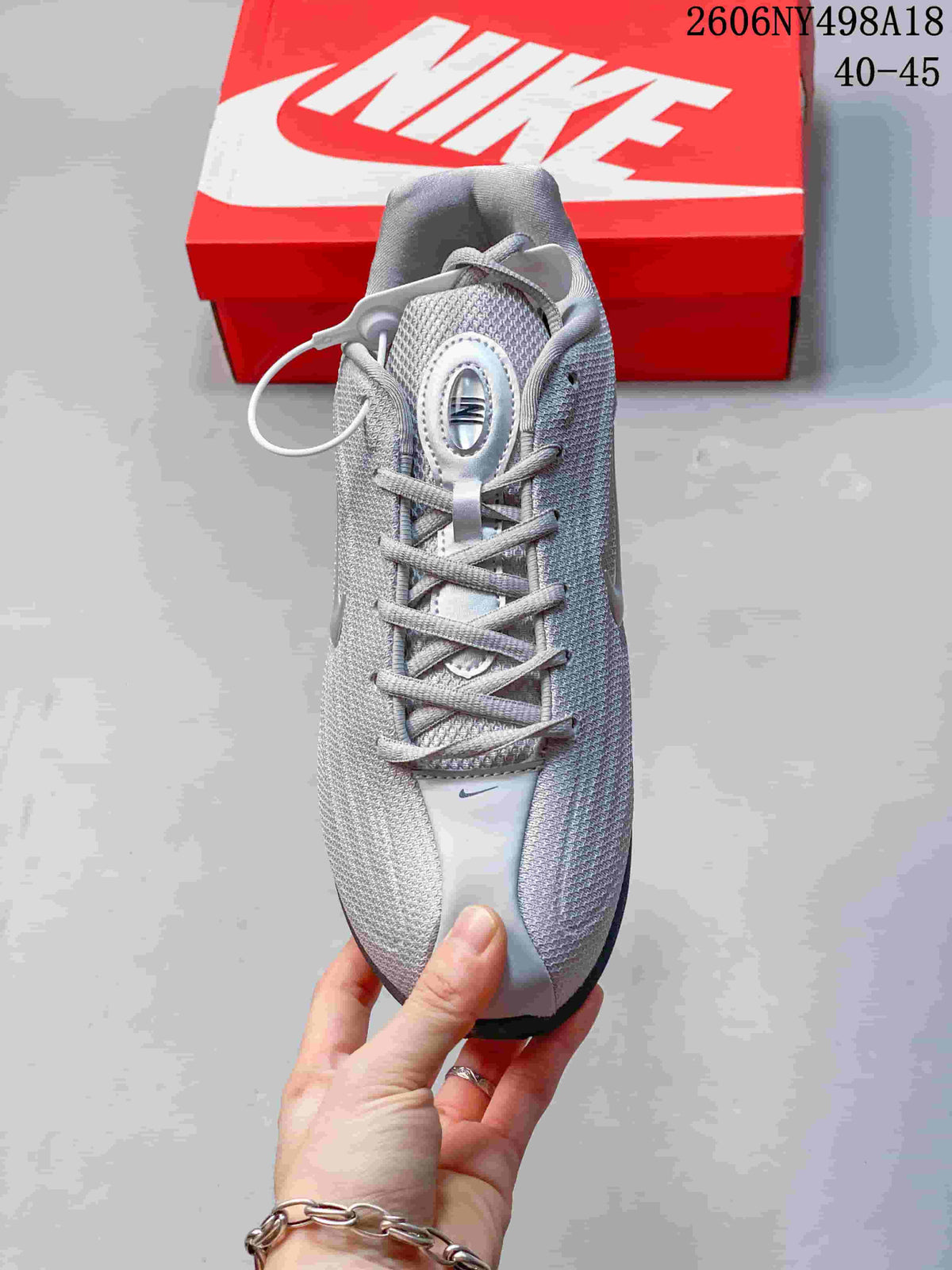 Top view of a silver Nike Shox TL sneaker with laces and mesh-look upper