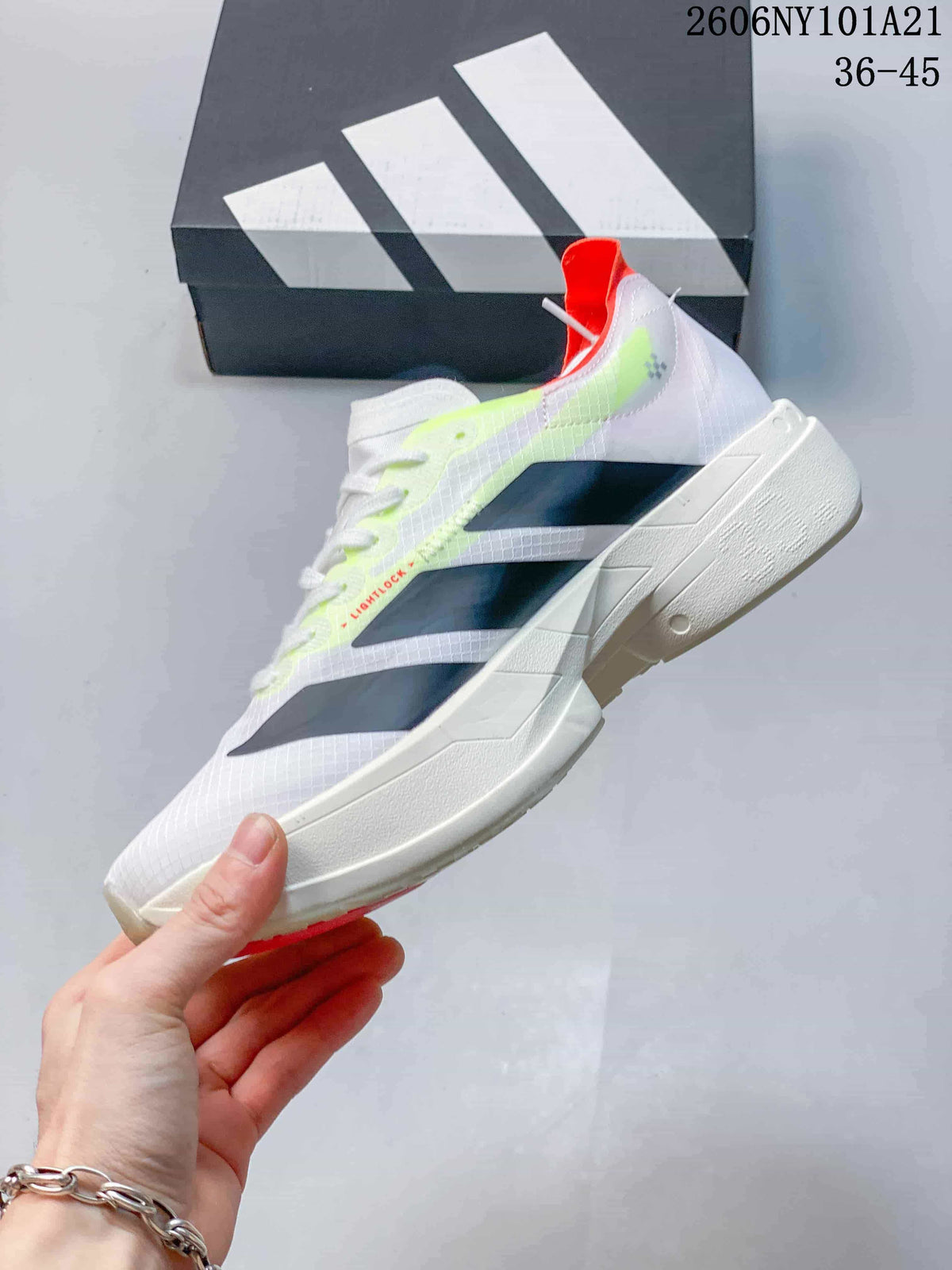 Side view of a white Adidas shoe with dark stripes, neon accents, and a sculpted sole.