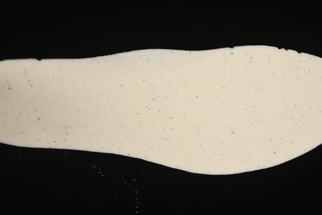 Close-up of a light-colored shoe insole with multicolored speckles.
