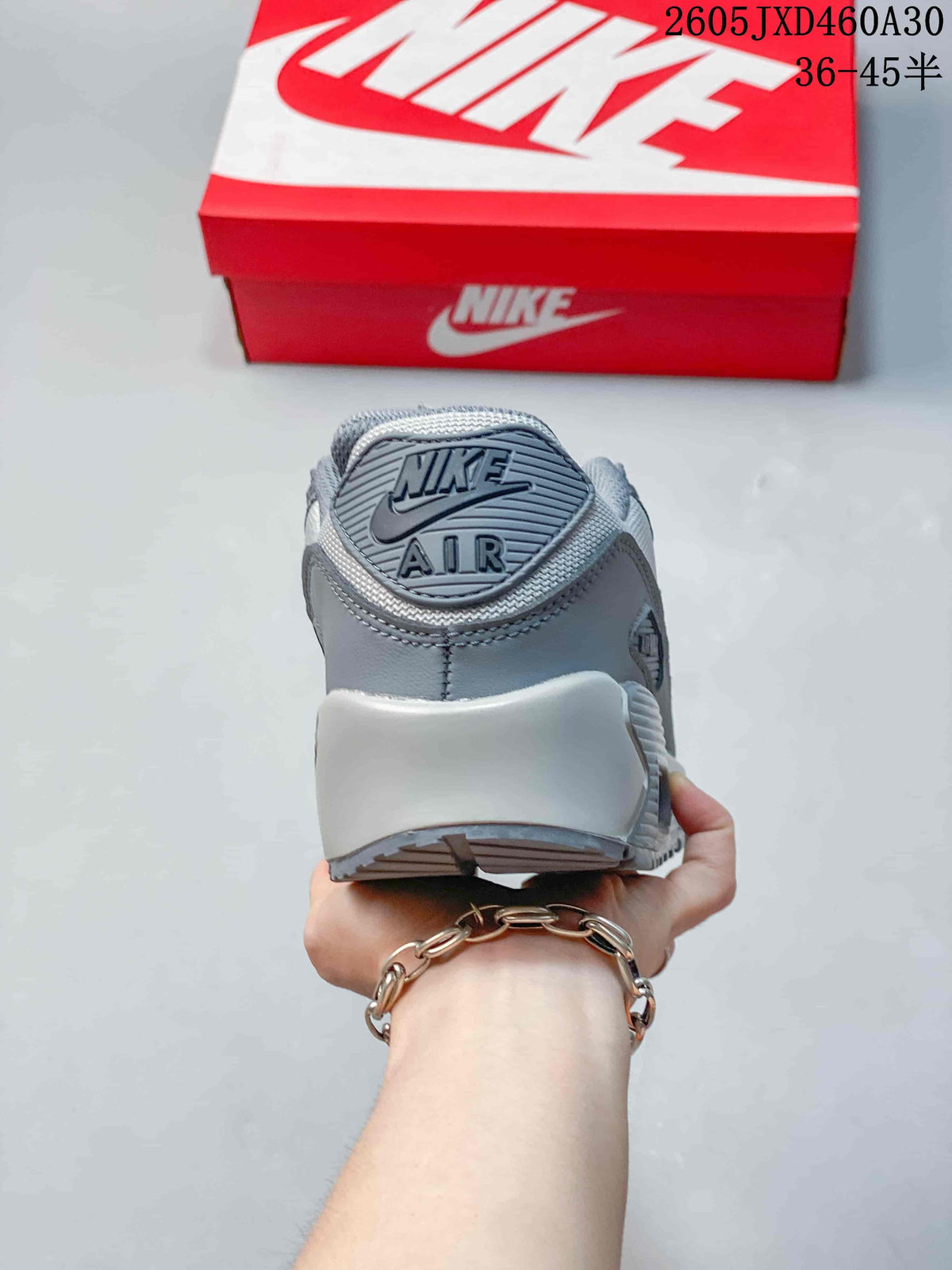 Rear view of a grey Nike Air Max 90 sneaker with heel branding
