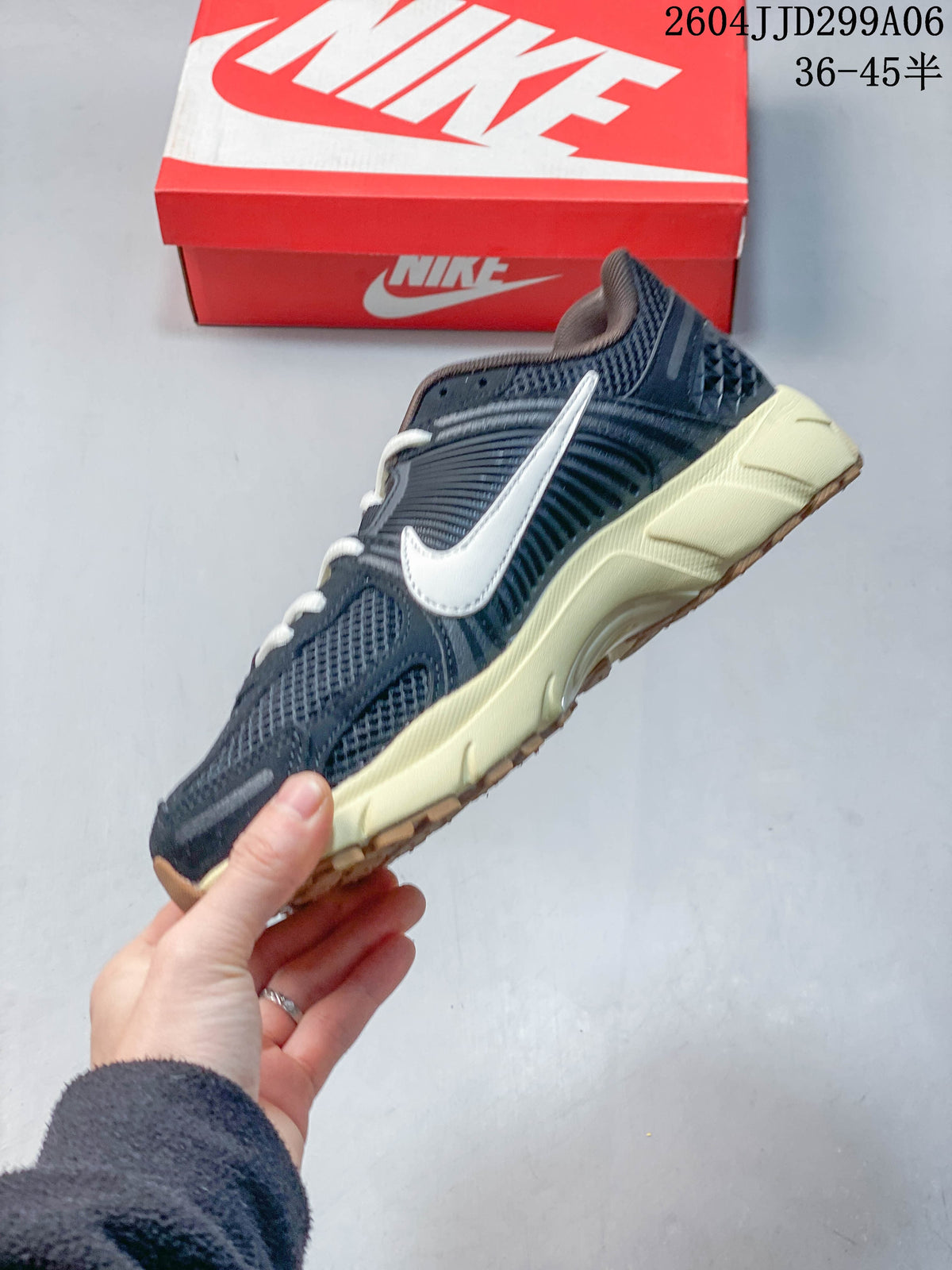 Side profile of a navy sneaker with light Swoosh detail and pale midsole