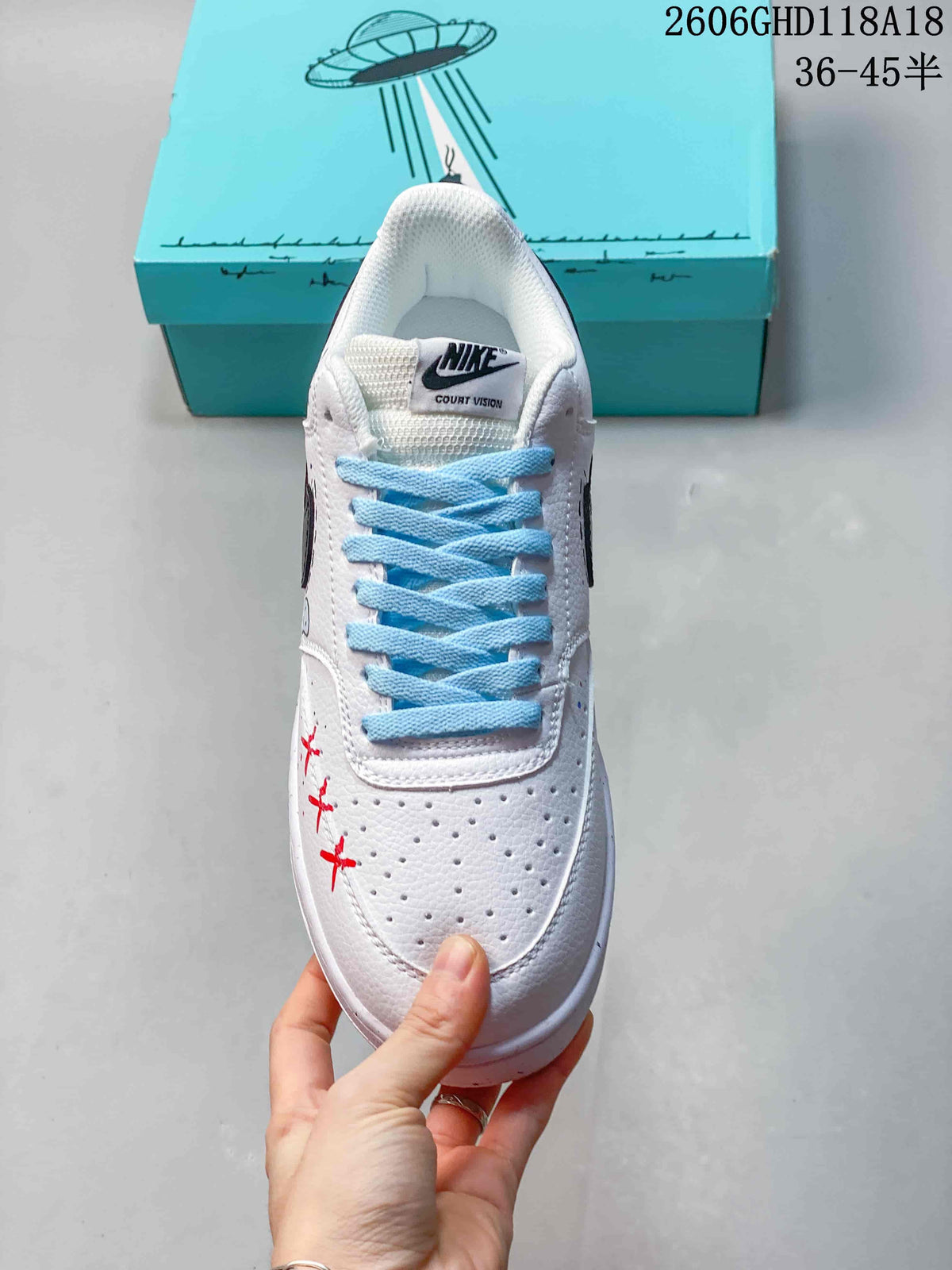 Top view of the white sneaker with pale blue laces and perforated toe