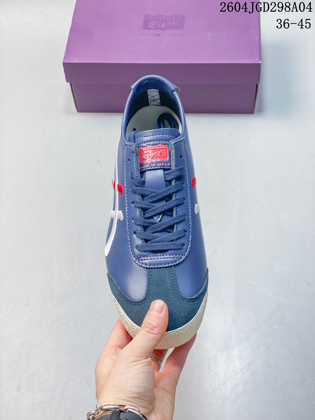 Front view of the lace-up sneaker with dark teal toe overlay