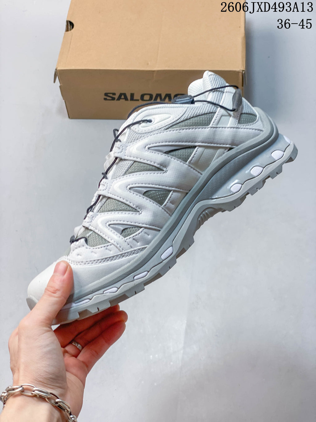 Side view of the white and grey low-top sneaker with mesh-look panels and quick laces.