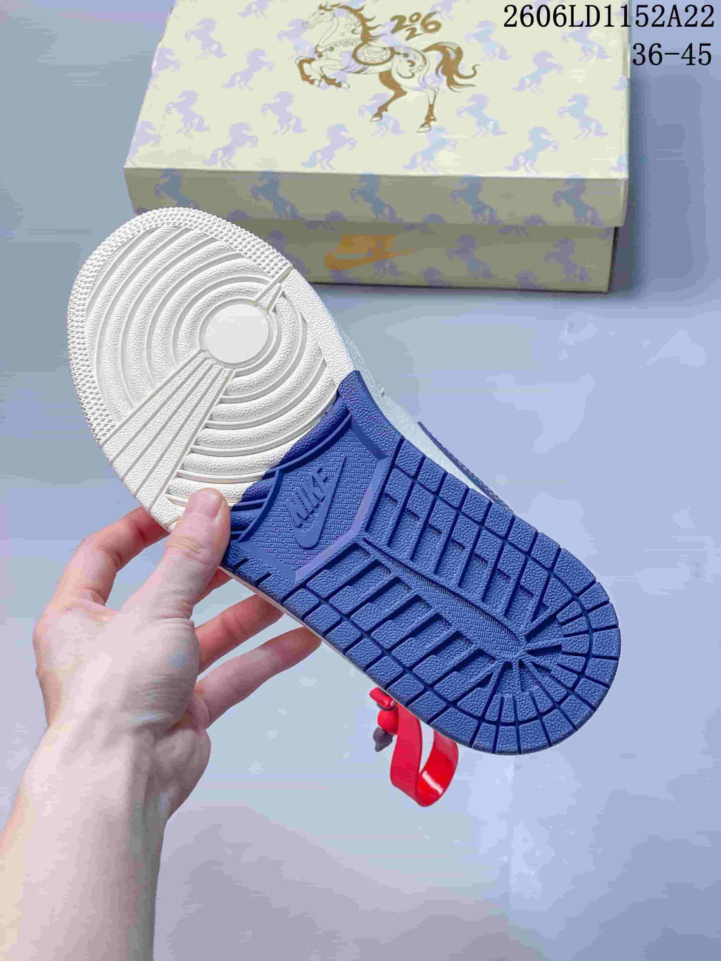 View of the sneaker outsole, with white and blue sections and patterned tread