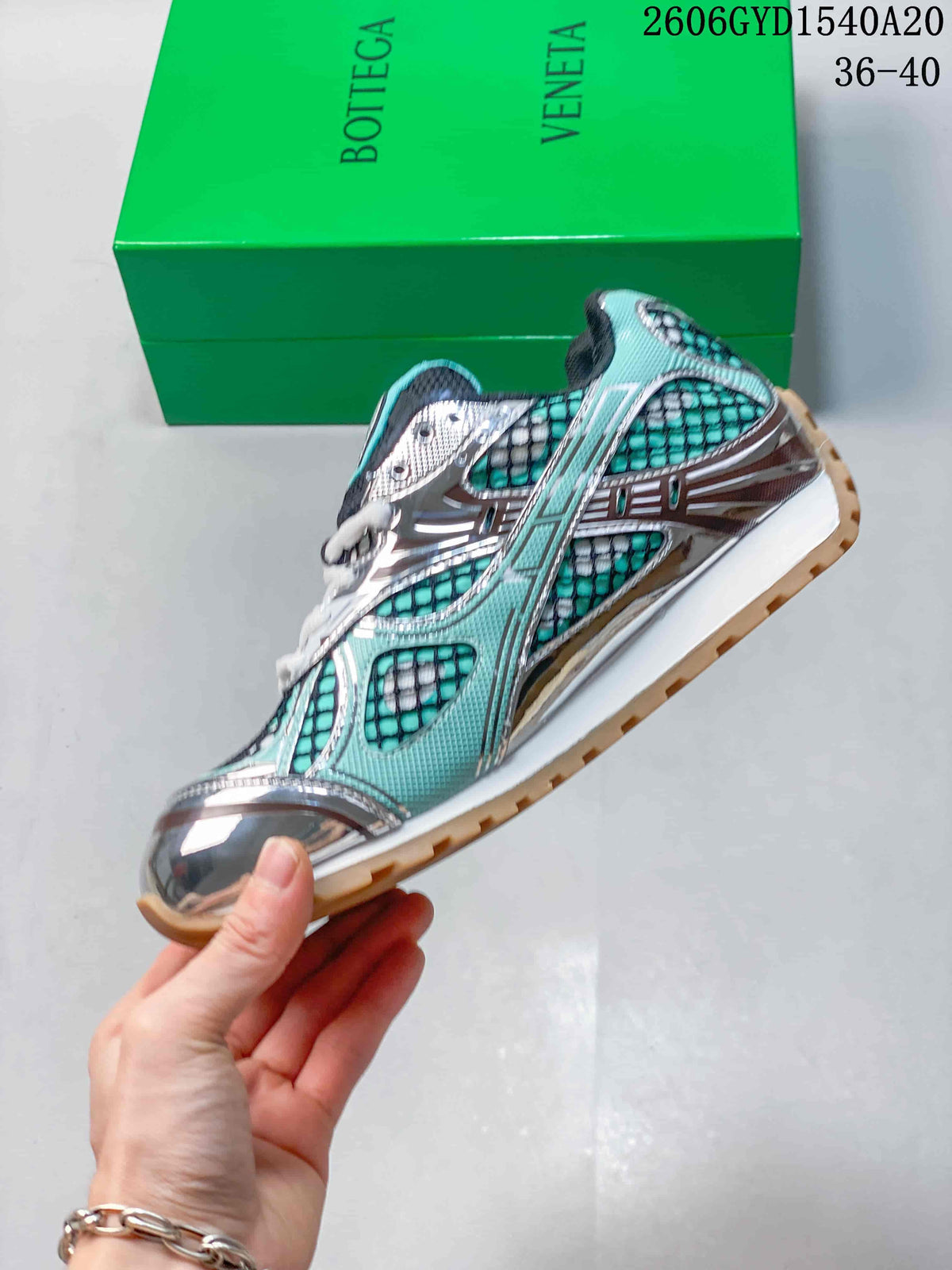 Side view of a turquoise and silver Bottega Veneta Orbit runner sneaker