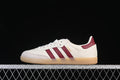 Side view of a cream adidas Samba sneaker with burgundy stripes and a gum-colored sole.
