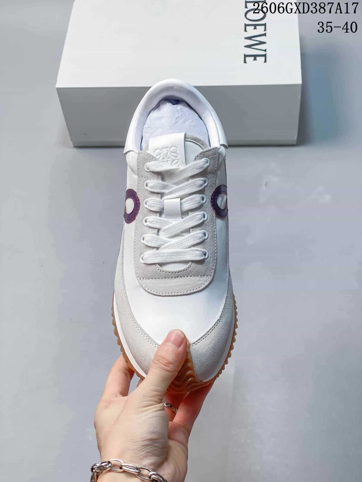 Front view showing white laces, gray overlays, and purple side accents